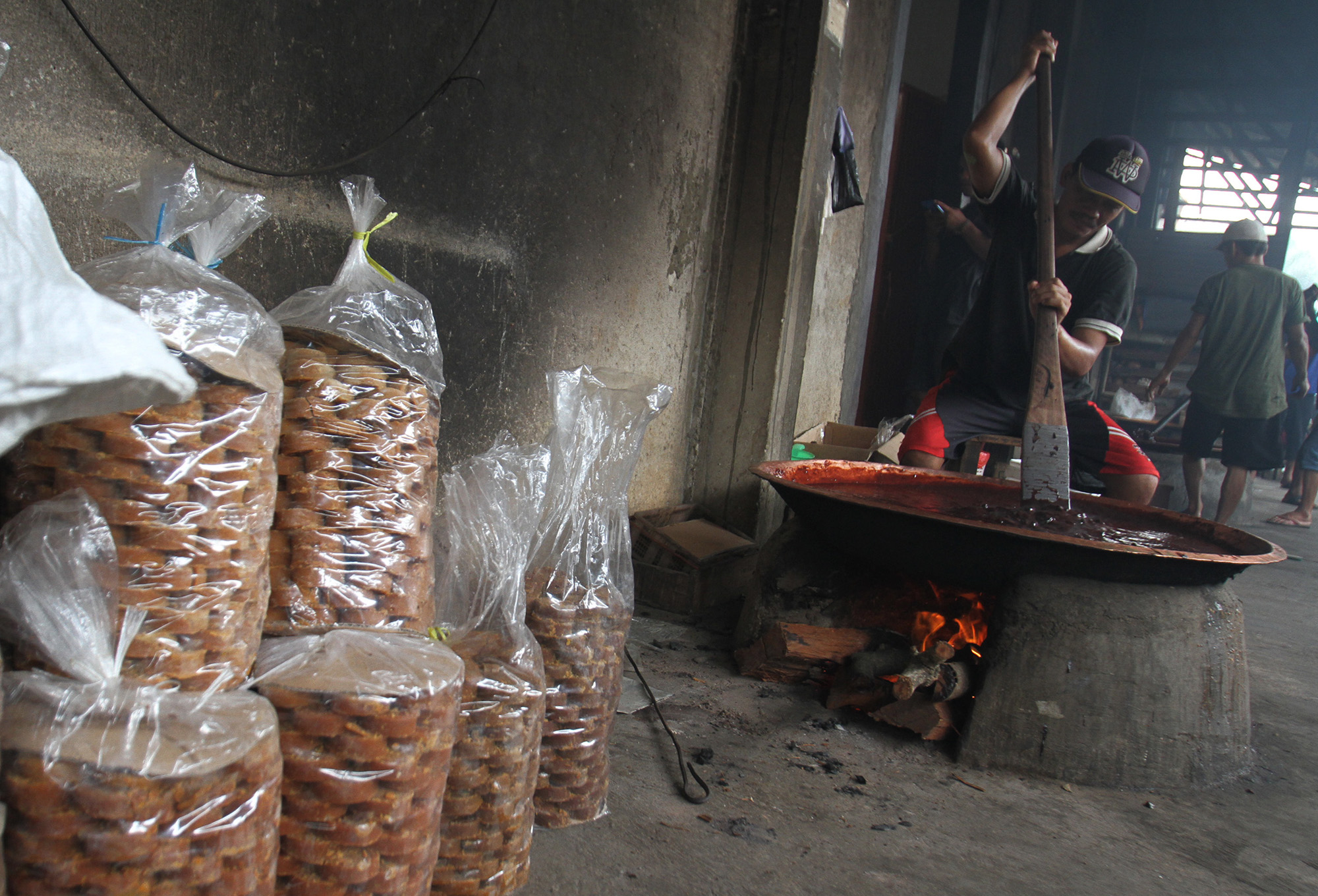 Pekerja memasak dodol Betawi dengan tungku kayu bakar di Sentra Dodol Betawi Wan Salmah di Kawasan Pejaten Timur, Pasar Minggu, Jakarta Selatan, Sabtu (16/3). (Sinarharapan.com/Oke Atmaja)