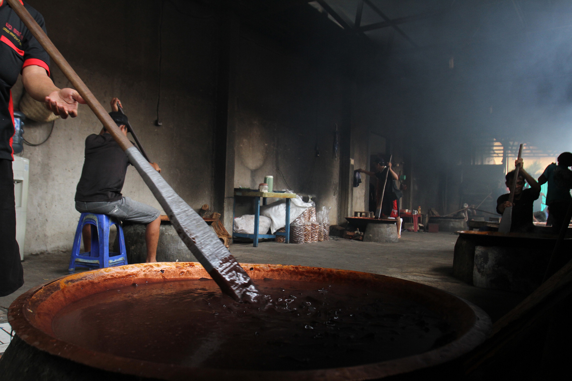 Pekerja memasak dodol Betawi dengan tungku kayu bakar di Sentra Dodol Betawi Wan Salmah di Kawasan Pejaten Timur, Pasar Minggu, Jakarta Selatan, Sabtu (16/3). (Sinarharapan.com/Oke Atmaja)