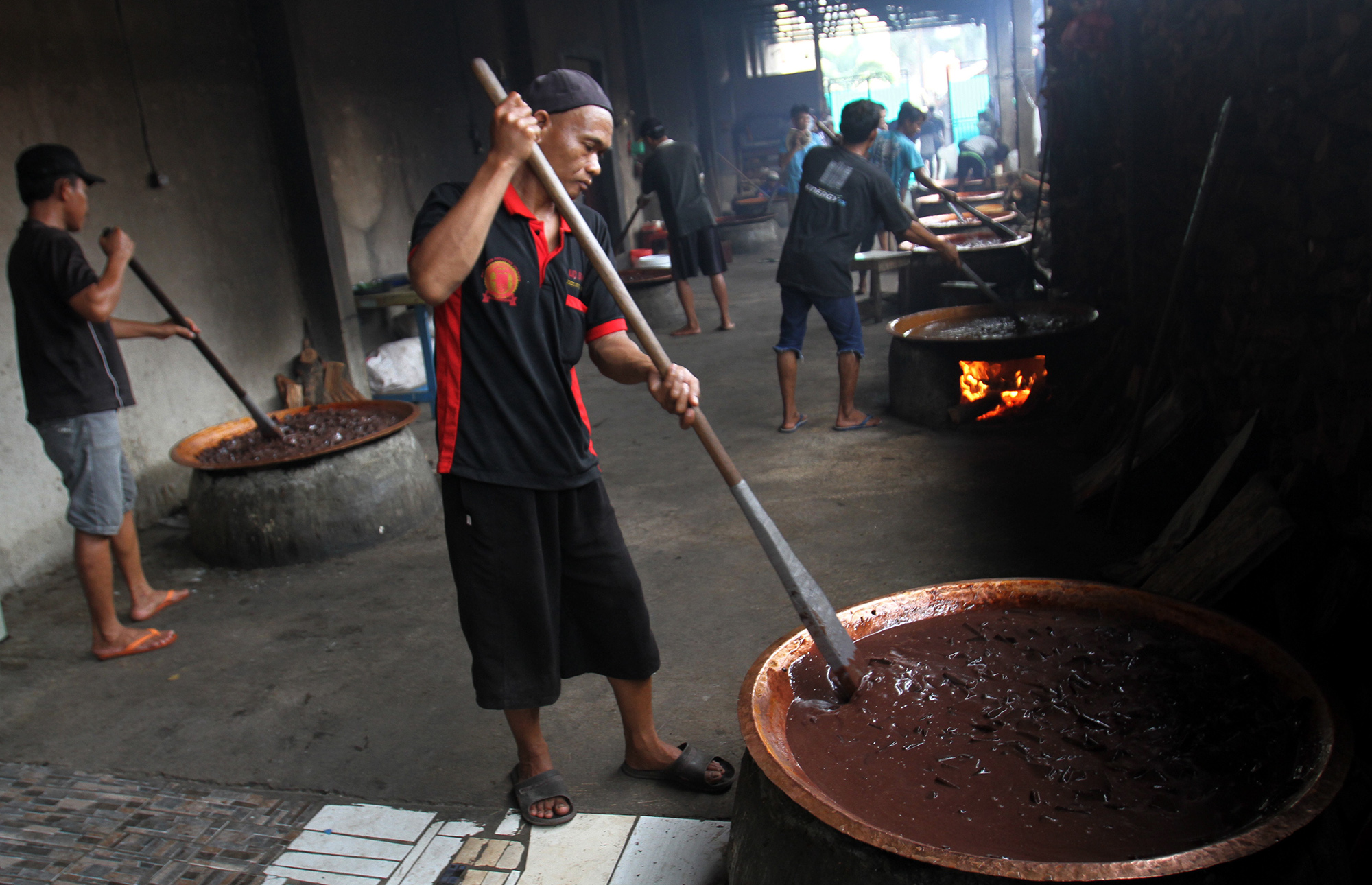 Pekerja memasak dodol Betawi dengan tungku kayu bakar di Sentra Dodol Betawi Wan Salmah di Kawasan Pejaten Timur, Pasar Minggu, Jakarta Selatan, Sabtu (16/3). (Sinarharapan.com/Oke Atmaja)