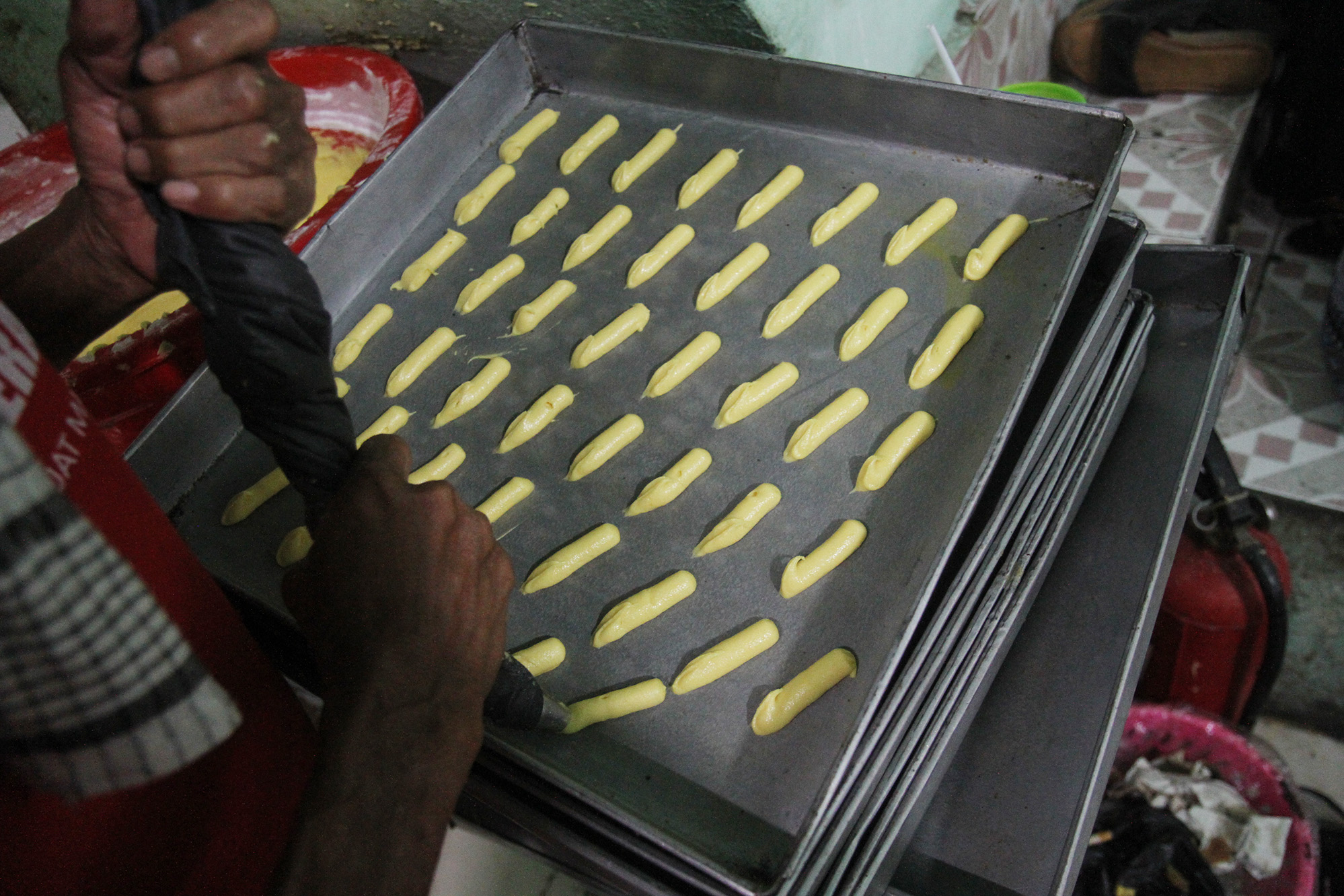 Pekerja menyelesaikan pembuatan kue kering di industri rumahan Butter Cokies Pusaka Kwitang, Jakarta, Rabu (27/3/2024).(Indonesiaglobe/Oke Atmaja)