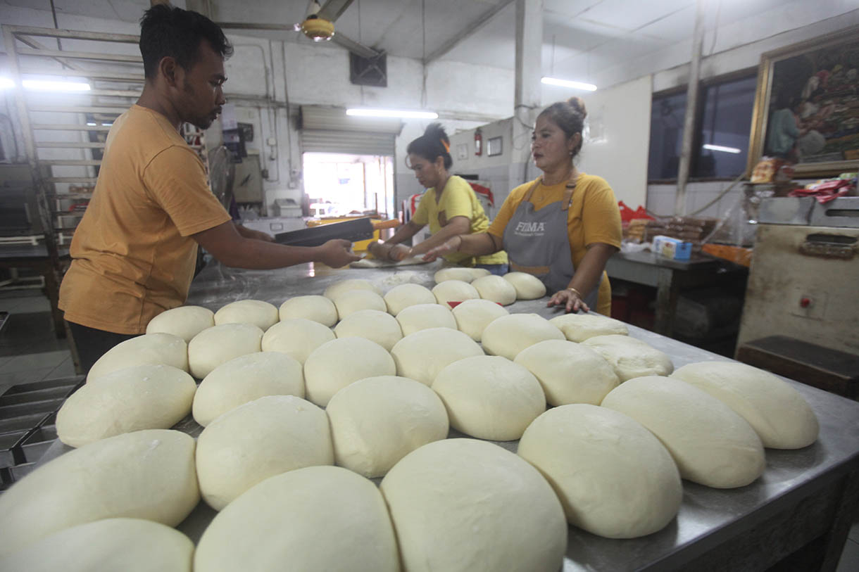 Pekerja memasukkan roti ke dalam oven di toko roti Gelora, Jatinegara, Jakarta, Rabu (6/11/2024).(BeritaNasional.com/Oke Atmaja)