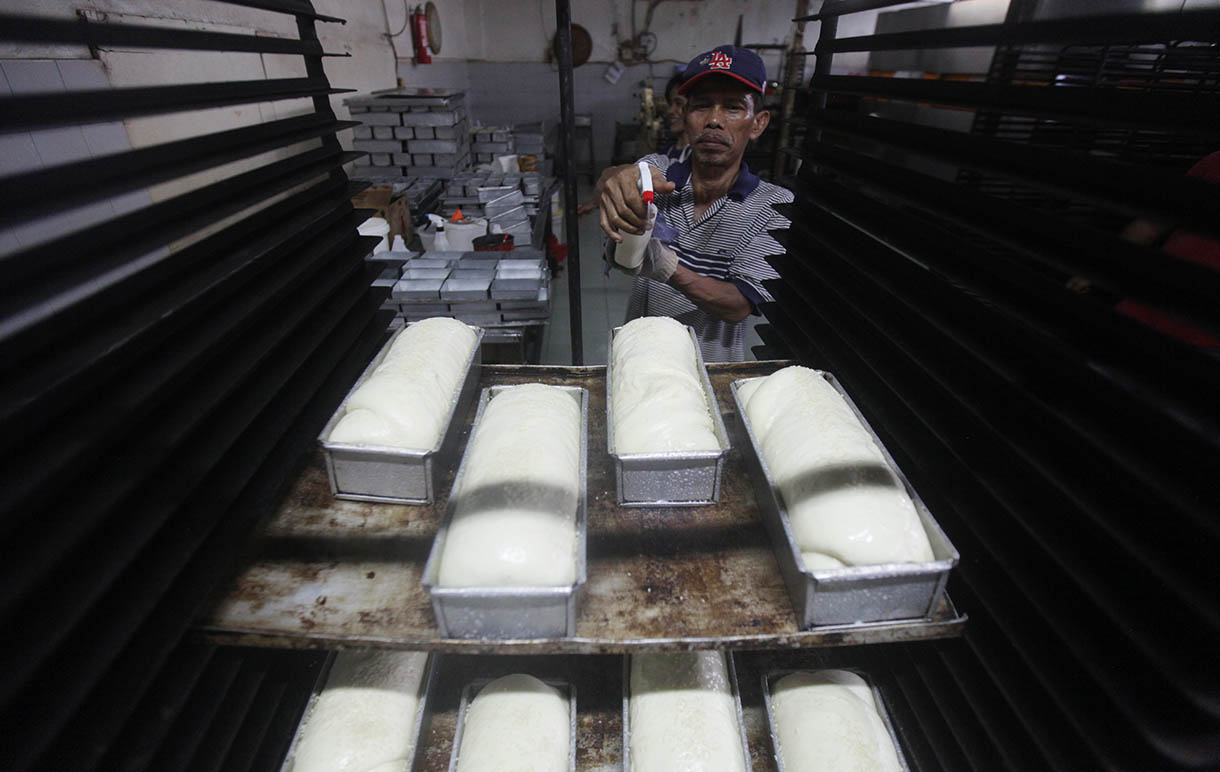 Pekerja memasukkan roti ke dalam oven di toko roti Gelora, Jatinegara, Jakarta, Rabu (6/11/2024).(BeritaNasional.com/Oke Atmaja)