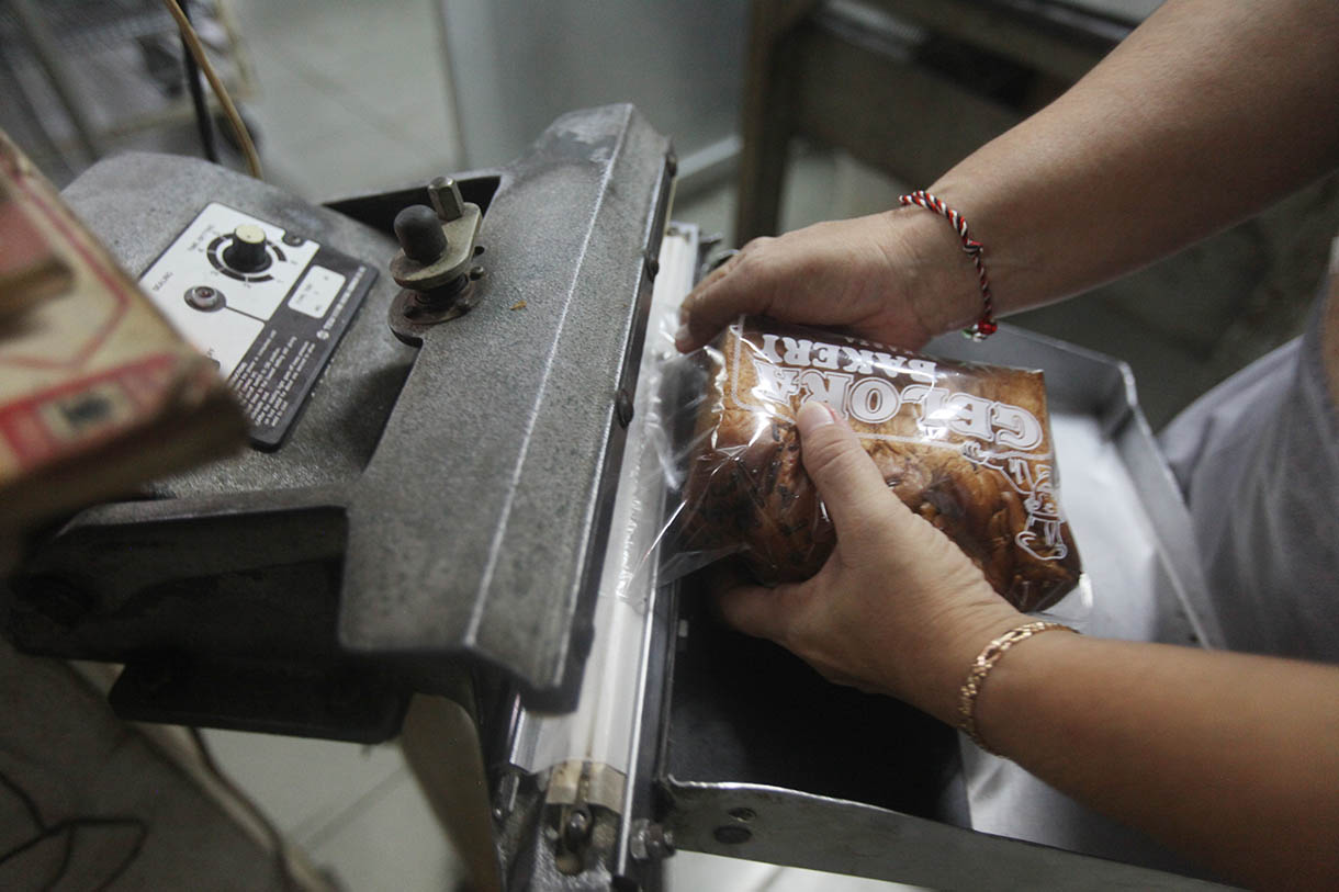 Pekerja memasukkan roti ke dalam oven di toko roti Gelora, Jatinegara, Jakarta, Rabu (6/11/2024).(BeritaNasional.com/Oke Atmaja)