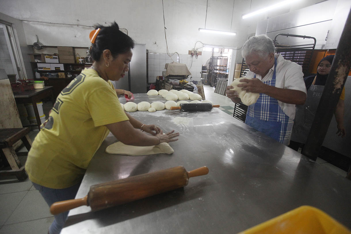 Pekerja memasukkan roti ke dalam oven di toko roti Gelora, Jatinegara, Jakarta, Rabu (6/11/2024).(BeritaNasional.com/Oke Atmaja)