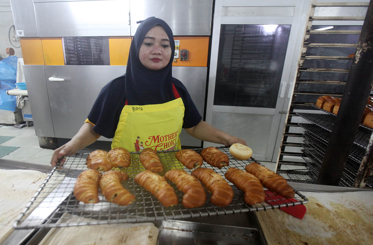 Pekerja memasukkan roti ke dalam oven di toko roti Gelora, Jatinegara, Jakarta, Rabu (6/11/2024).(BeritaNasional.com/Oke Atmaja)