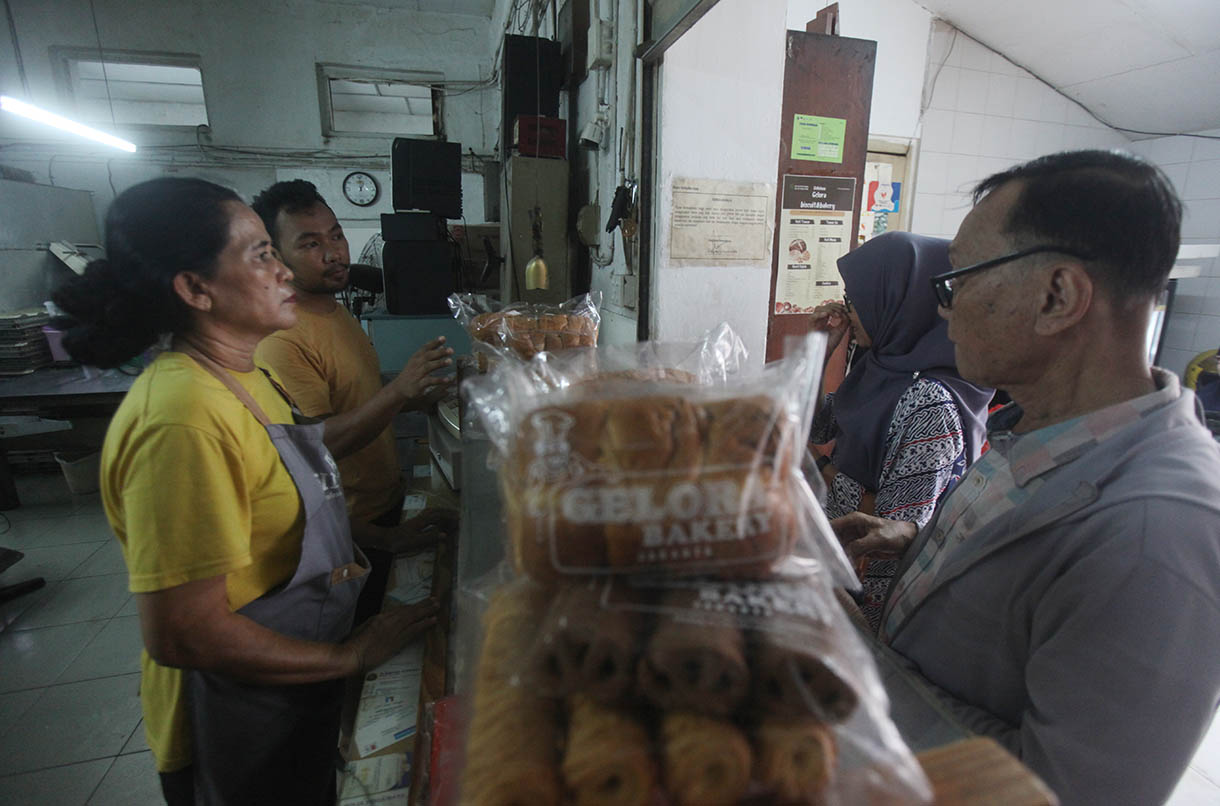 Pekerja memasukkan roti ke dalam oven di toko roti Gelora, Jatinegara, Jakarta, Rabu (6/11/2024).(BeritaNasional.com/Oke Atmaja)