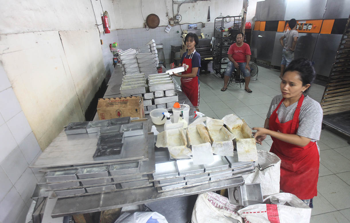 Pekerja memasukkan roti ke dalam oven di toko roti Gelora, Jatinegara, Jakarta, Rabu (6/11/2024).(BeritaNasional.com/Oke Atmaja)