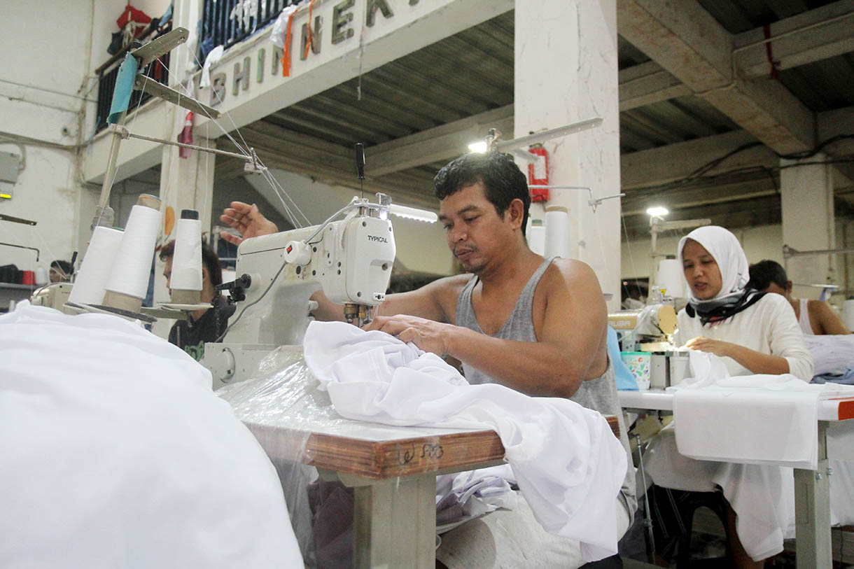 Sejumlah pekerja menyelesaikan pembuatan kaos di konveksi Sinergi Adv, Jakarta, Rabu (23/10/2024). (BeritaNasional.com/Oke Atmaja)