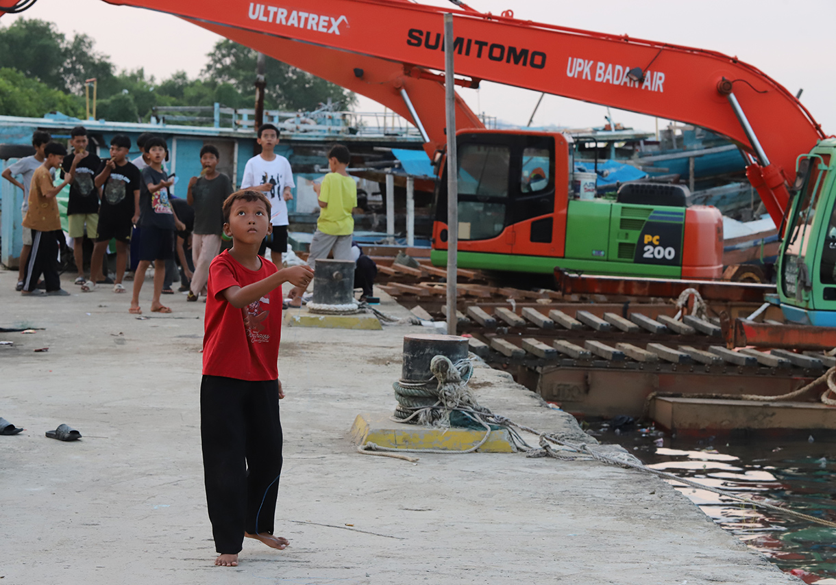 Anak-anak bermain layang-layang di dermaga muara angke, Jakarta, Minggu (13/7/2025).  (Beritanasional.com/Oke Atmaja)