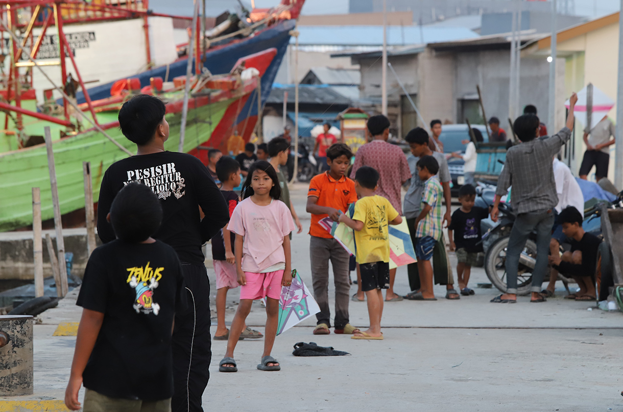 Anak-anak bermain layang-layang di dermaga muara angke, Jakarta, Minggu (13/7/2025).  (Beritanasional.com/Oke Atmaja)