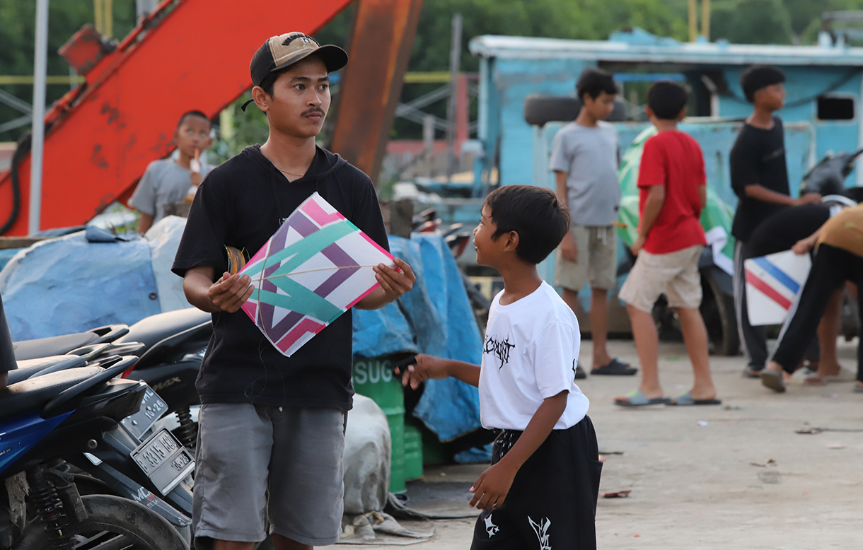 Anak-anak bermain layang-layang di dermaga muara angke, Jakarta, Minggu (13/7/2025).  (Beritanasional.com/Oke Atmaja)