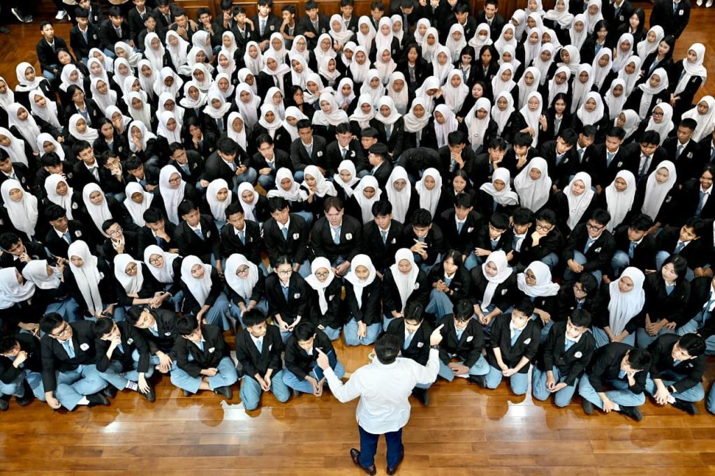 Sekretaris Kabinet (Seskab) Teddy Indra Wijaya (kanan) berbincang dengan siswa Sekolah Menengah Kejuruan Negeri (SMKN) 19 Jakarta Pusat saat berkunjung di Kompleks Istana Kepresidenan, Jakarta, Selasa (7/4/2026). (Biropers)