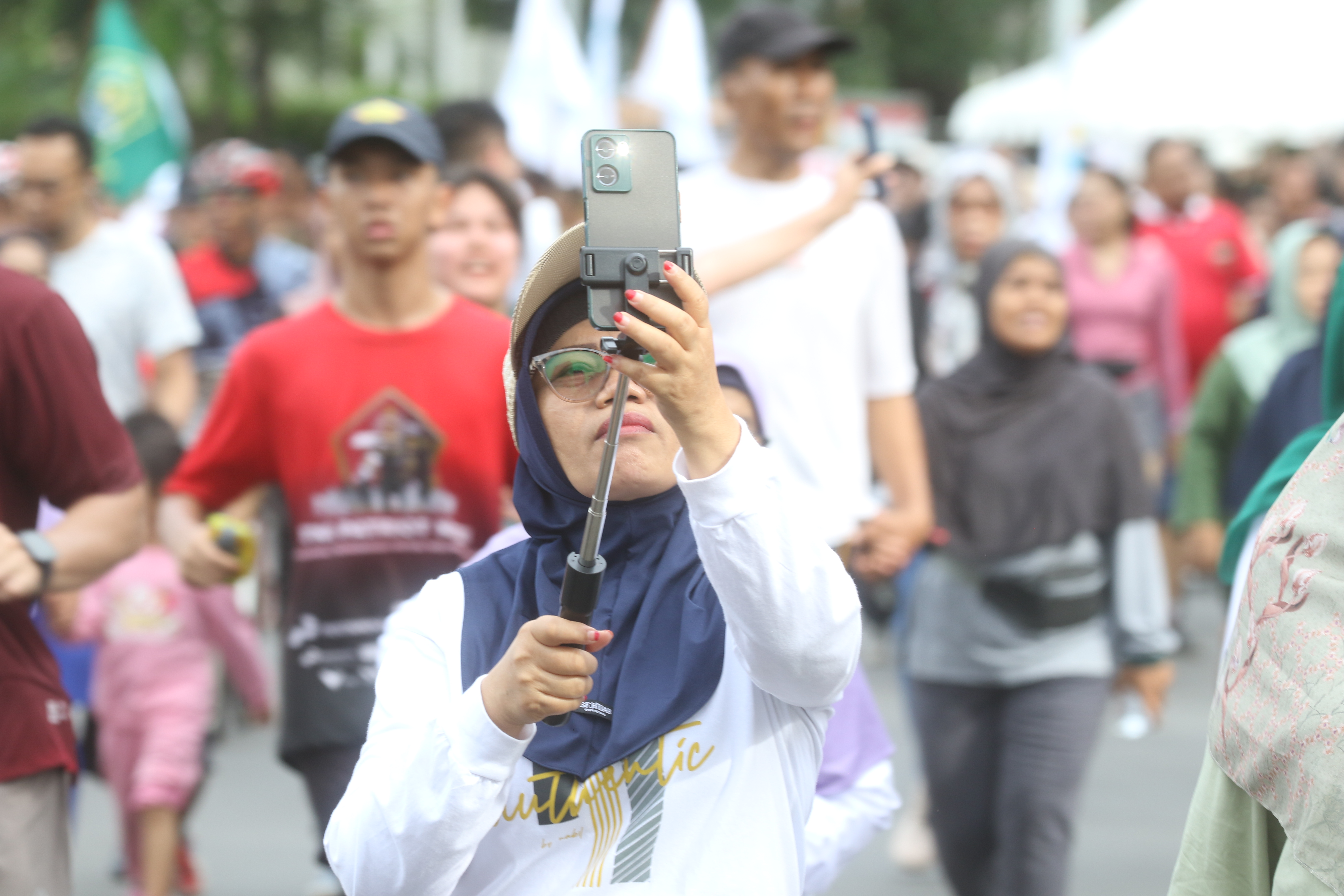 Warga berolahraga saat Hari Bebas Kendaraan Bermotor (HBKB) di Kawasan Bundaran HI, Jakarta, Minggu (23/11/2025). (Beritanasional.com/Oke Atmaja)