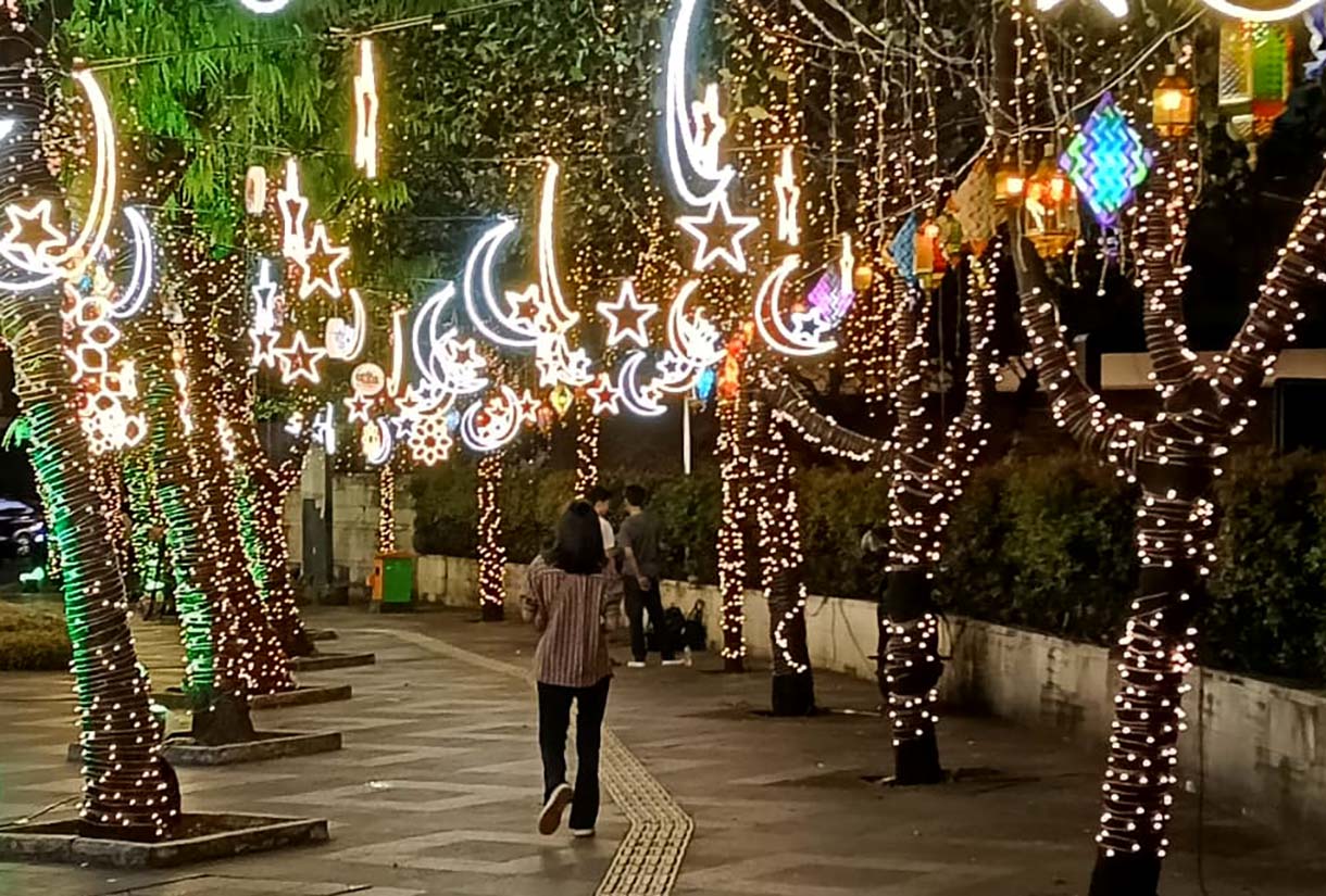 Sejumlah warga menikmati suasana di sekitar aneka lampu hias pada Jakarta Light Festival 2026 di kawasan Bundaran HI, Jakarta, Jumat (13/3/2026). (Beritanasional.com/Oke Atmaja)