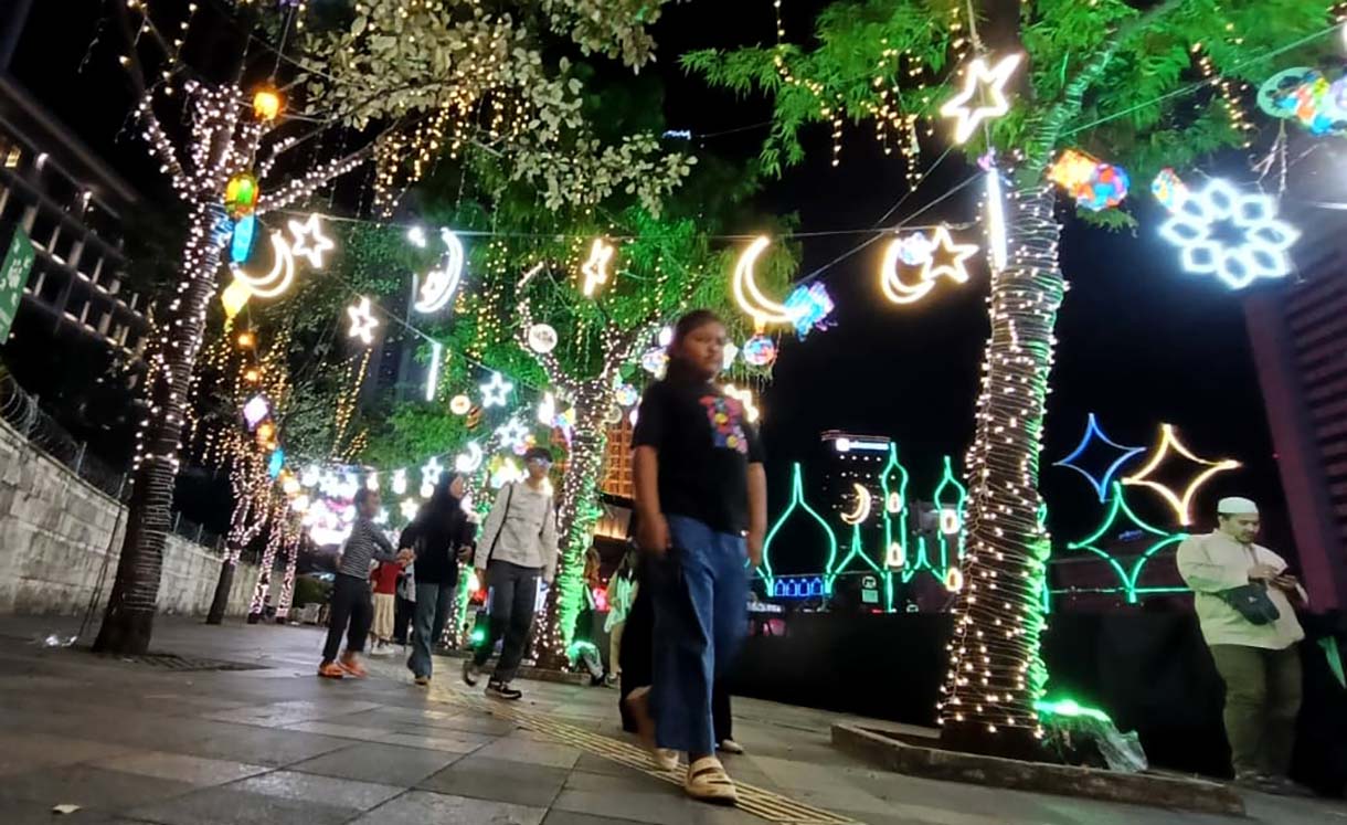 Sejumlah warga menikmati suasana di sekitar aneka lampu hias pada Jakarta Light Festival 2026 di kawasan Bundaran HI, Jakarta, Jumat (13/3/2026). (Beritanasional.com/Oke Atmaja)