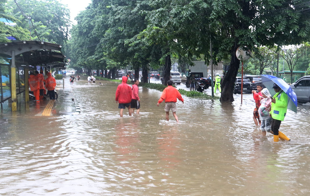 Petugas mengatur lalu lintas jalan di tengah genangan banjir yang merendam di sekitar Cempaka Putih, Jakarta, Kamis (22/1/2026).(Beritanasional.com/Oke Atmaja)