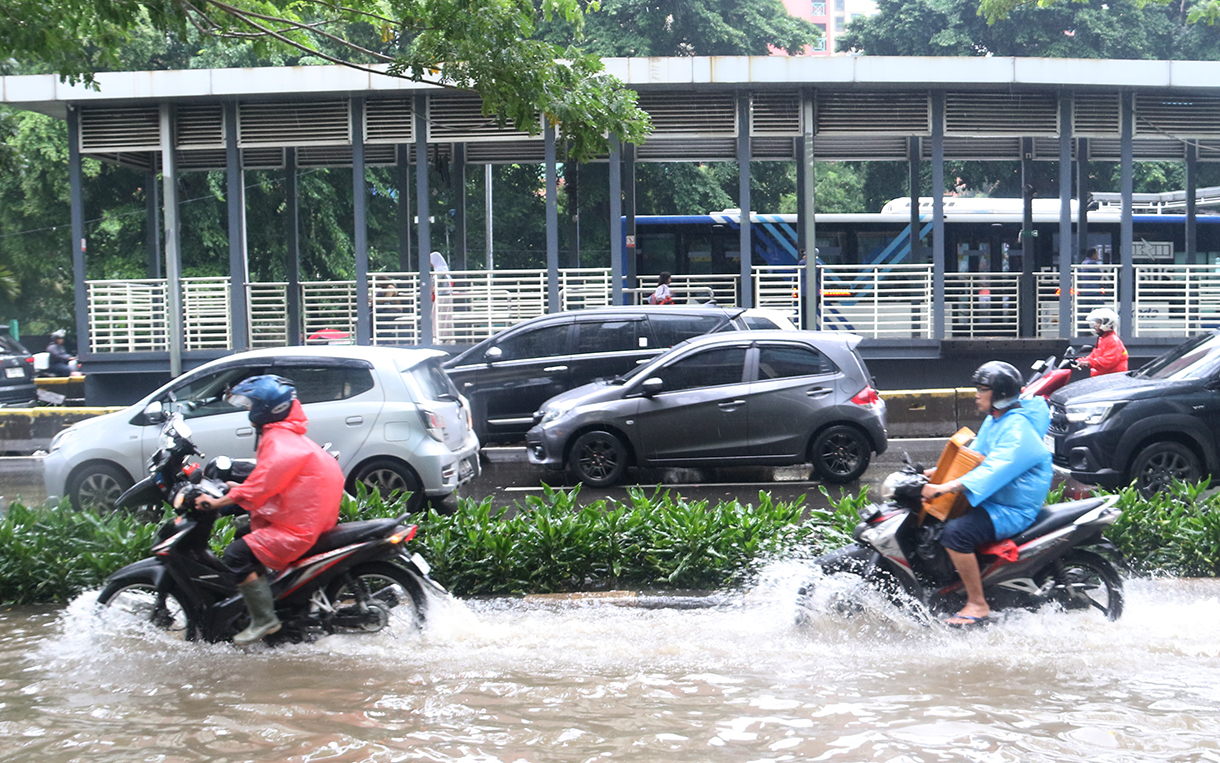 Petugas mengatur lalu lintas jalan di tengah genangan banjir yang merendam di sekitar Cempaka Putih, Jakarta, Kamis (22/1/2026).(Beritanasional.com/Oke Atmaja)