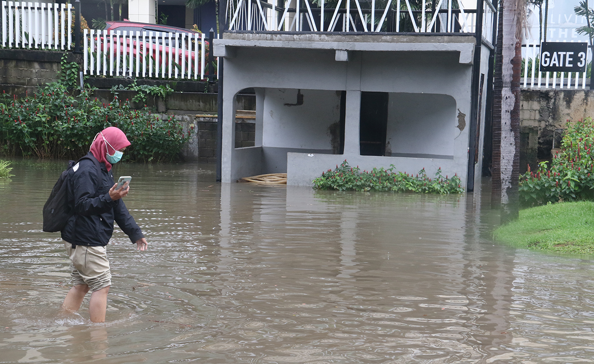 Pejalan kaki menerjang genangan banjir yang merendam di sekitar Cempaka Putih, Jakarta, Kamis (22/1/2026). (Beritanasional/Oke Atmaja)