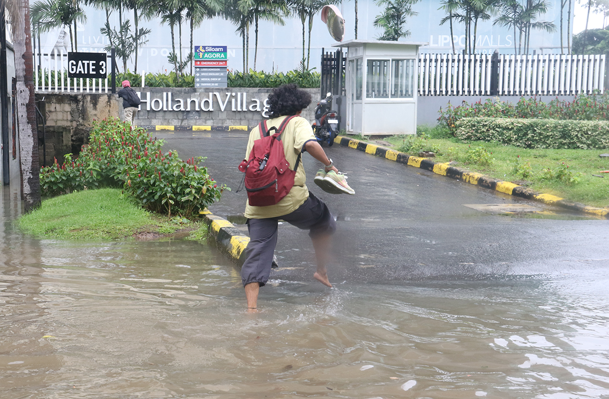 Petugas mengatur lalu lintas jalan di tengah genangan banjir yang merendam di sekitar Cempaka Putih, Jakarta, Kamis (22/1/2026).(Beritanasional.com/Oke Atmaja)