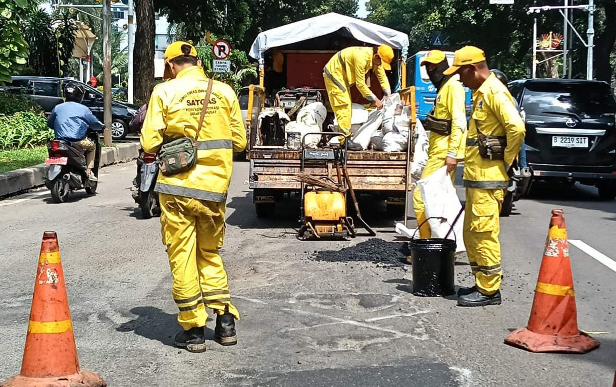 Petugas Dinas Bina Marga melakukan pengaspalan di jalur Jalan Kebon Sirih, Jakarta, Senin (26/1/2026).  (Beritanasional.com/Oke Atmaja)