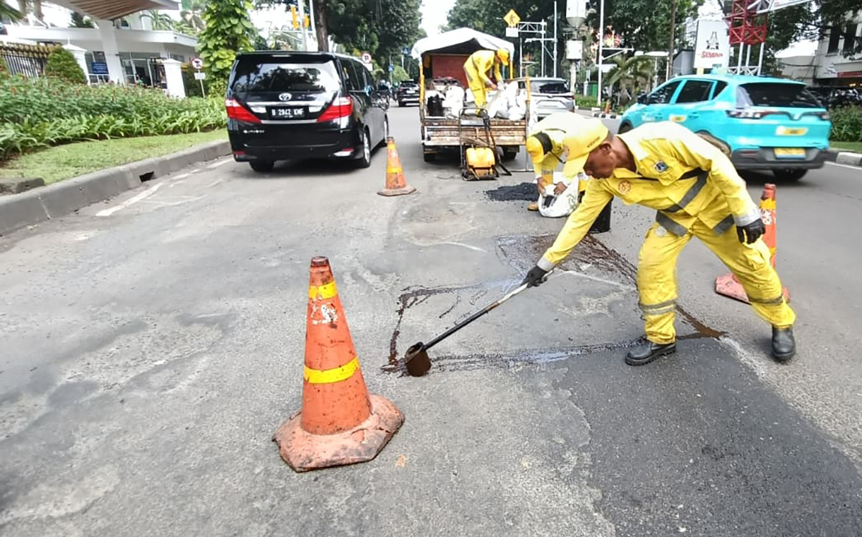 Petugas Dinas Bina Marga melakukan pengaspalan di jalur Jalan Kebon Sirih, Jakarta, Senin (26/1/2026).  (Beritanasional.com/Oke Atmaja)