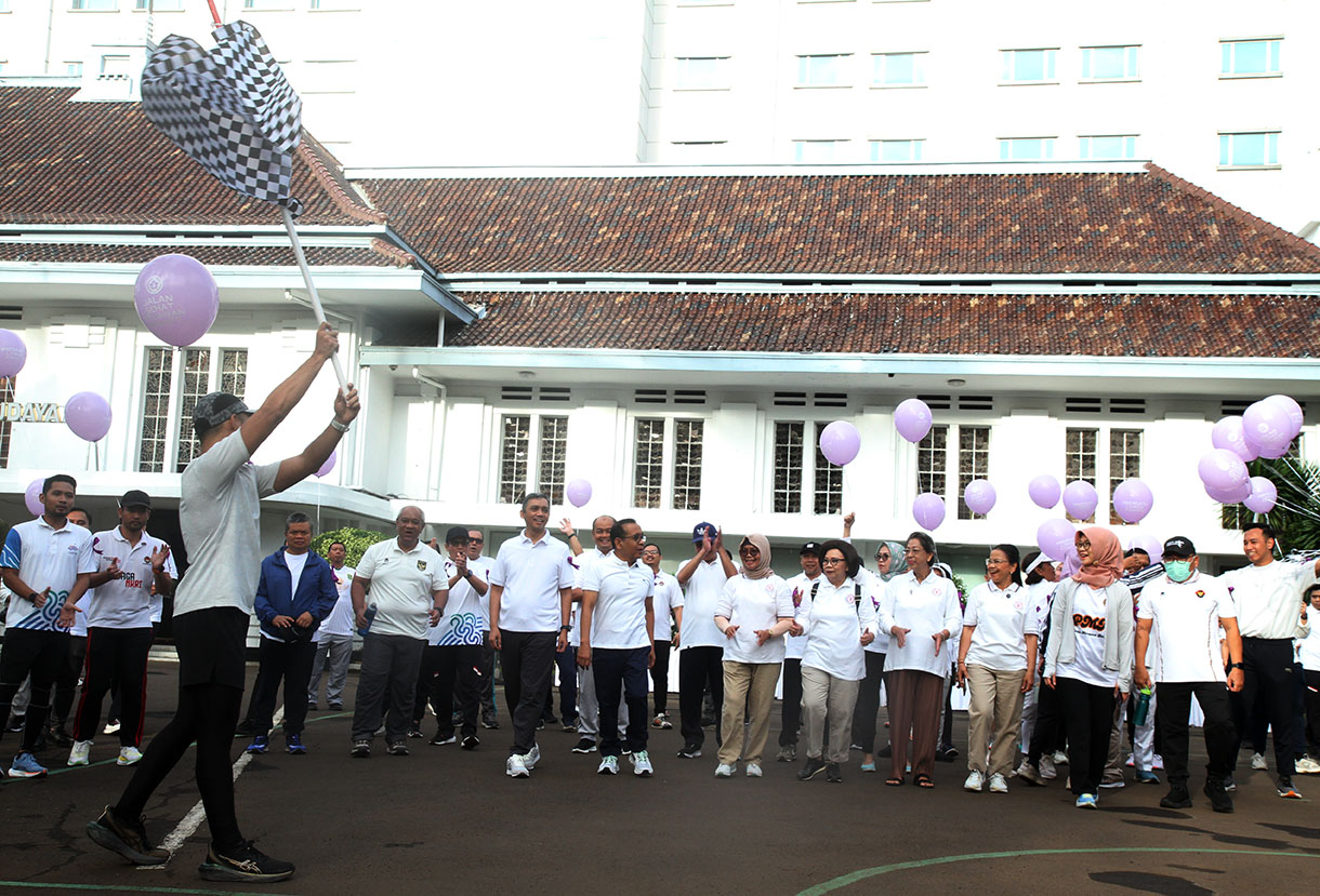 Menteri Koordinator Bidang Pembangunan Manusia dan Kebudayaan (Menko PMK) Pratikno (kedua kiri depan) bersama pengurus penyintas kanker Yayasan Kanker Indonesia Rini Hoepoedio (kedua kanan) dan sejumlah penyintas kanker mengikuti jalan sehat melawan kanker di halaman Monas, Jakarta, Rabu (5/2/2025).  (Beritanasional.com/Oke Atmaja)