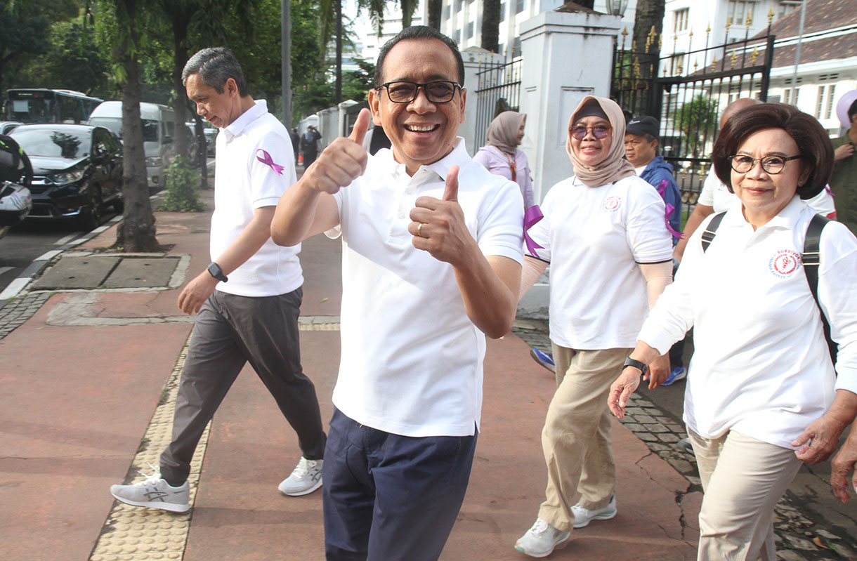 Menteri Koordinator Bidang Pembangunan Manusia dan Kebudayaan (Menko PMK) Pratikno (kedua kiri depan) bersama pengurus penyintas kanker Yayasan Kanker Indonesia Rini Hoepoedio (kedua kanan) dan sejumlah penyintas kanker mengikuti jalan sehat melawan kanker di halaman Monas, Jakarta, Rabu (5/2/2025).  (Beritanasional.com/Oke Atmaja)