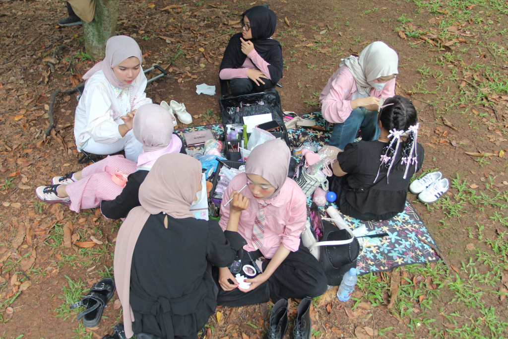 Mahasiswa melayani jasa rias wajah untuk penggemar Black Pink sebelum konser di Stadion Utama Gelora Bung Karno (SUGBK), Jakarta, Sabtu (01/11/2025). (Beritanasional.com/Oke Atmaja)