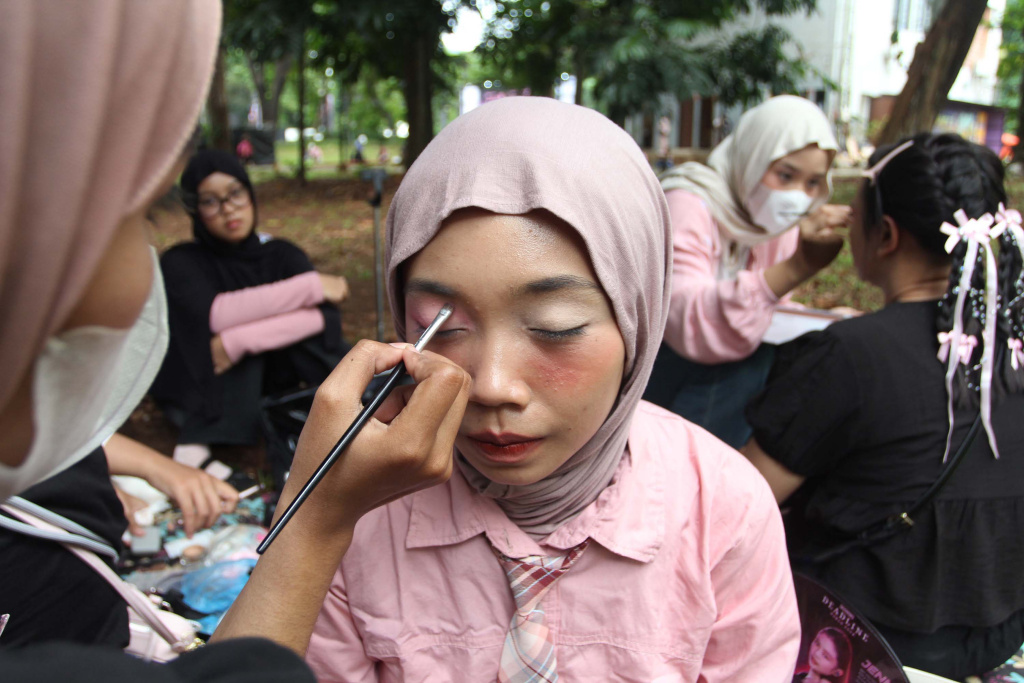 Mahasiswa melayani jasa rias wajah untuk penggemar Black Pink sebelum konser di Stadion Utama Gelora Bung Karno (SUGBK), Jakarta, Sabtu (01/11/2025). (Beritanasional.com/Oke Atmaja)