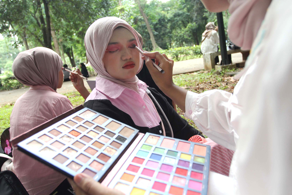 Mahasiswa melayani jasa rias wajah untuk penggemar Black Pink sebelum konser di Stadion Utama Gelora Bung Karno (SUGBK), Jakarta, Sabtu (01/11/2025). (Beritanasional.com/Oke Atmaja)
