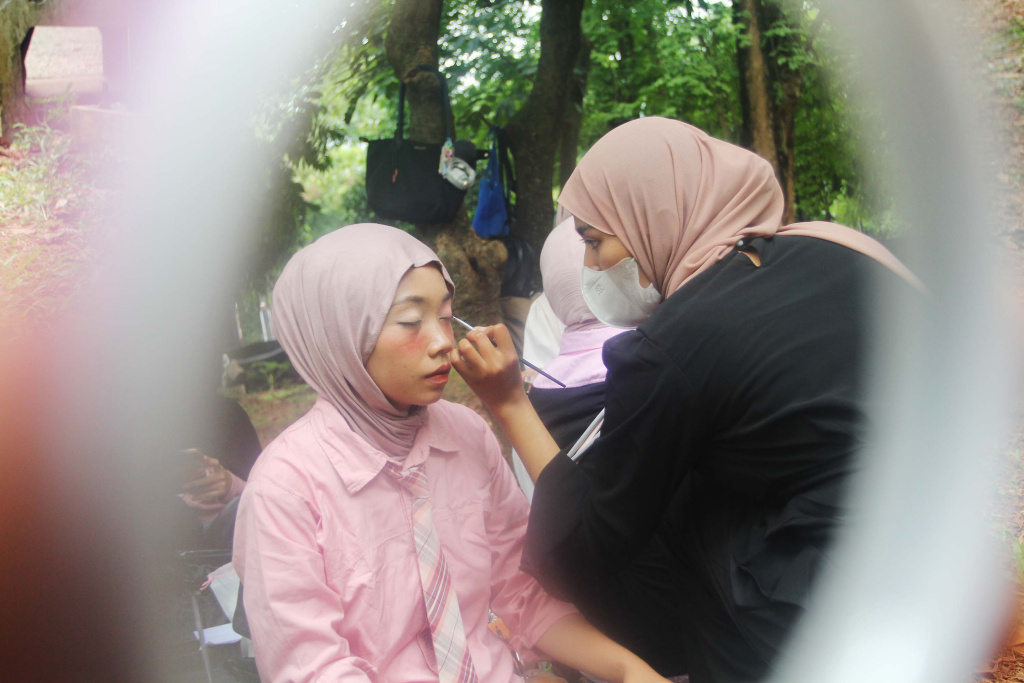 Mahasiswa melayani jasa rias wajah untuk penggemar Black Pink sebelum konser di Stadion Utama Gelora Bung Karno (SUGBK), Jakarta, Sabtu (01/11/2025). (Beritanasional.com/Oke Atmaja)