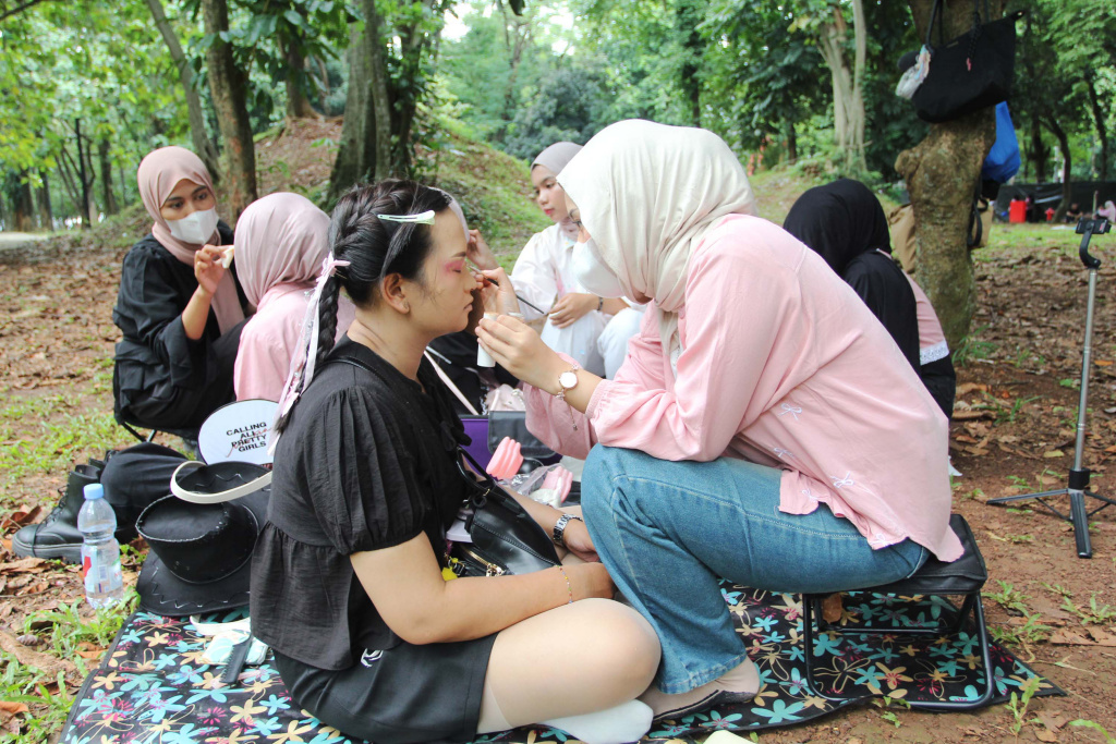 Mahasiswa melayani jasa rias wajah untuk penggemar Black Pink sebelum konser di Stadion Utama Gelora Bung Karno (SUGBK), Jakarta, Sabtu (01/11/2025). (Beritanasional.com/Oke Atmaja)