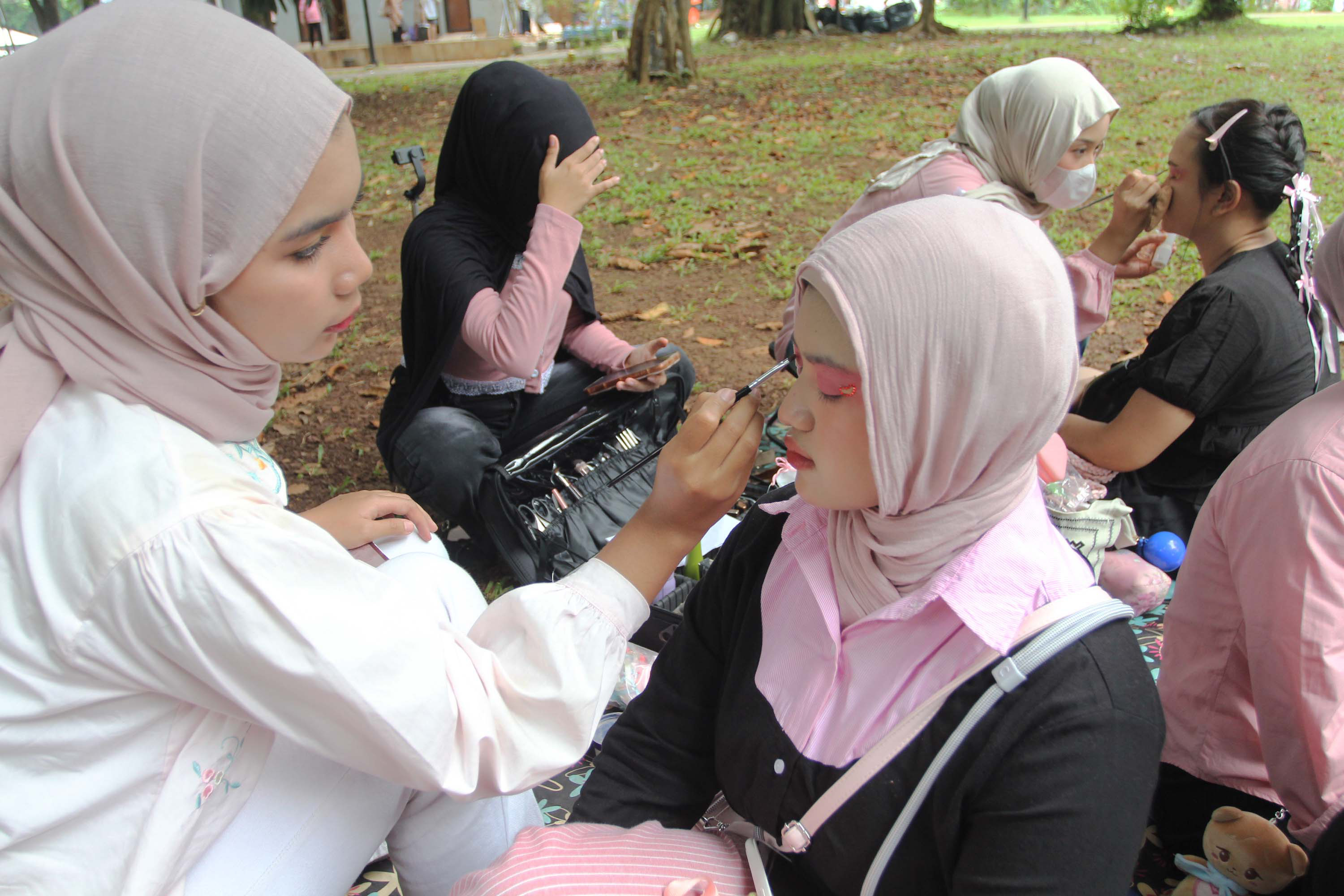 Mahasiswa melayani jasa rias wajah untuk penggemar Black Pink sebelum konser di Stadion Utama Gelora Bung Karno (SUGBK), Jakarta, Sabtu (01/11/2025). (Beritanasional.com/Oke Atmaja)