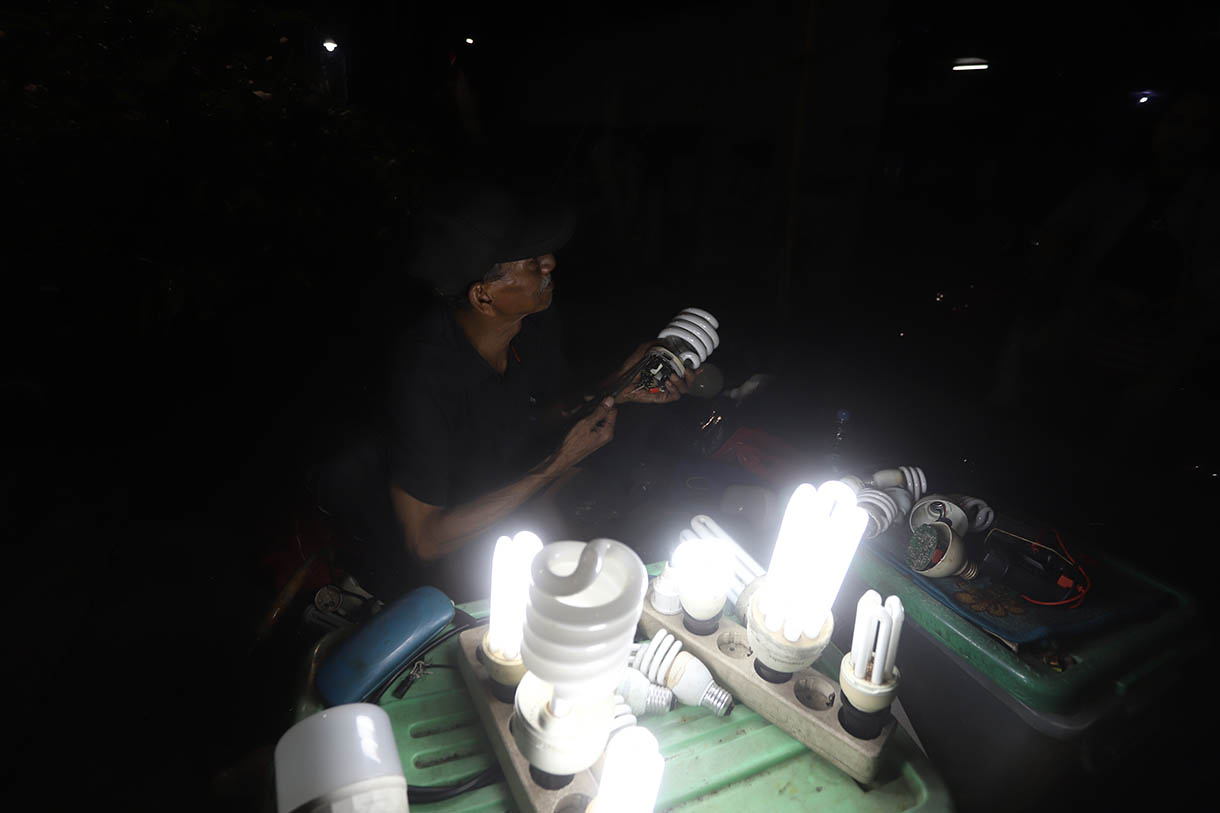 Pak Har (72 Tahun) memperbaiki lampu  bohlam di Lapaknya di Kawasan Kebayoran Lama, Jakarta Selatan, Selasa (15/10/2024).  (BeritaNasional.com/Oke Atmaja)