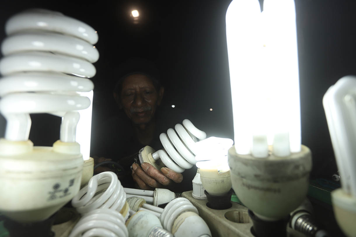 Pak Har (72 Tahun) memperbaiki lampu  bohlam di Lapaknya di Kawasan Kebayoran Lama, Jakarta Selatan, Selasa (15/10/2024).  (BeritaNasional.com/Oke Atmaja)