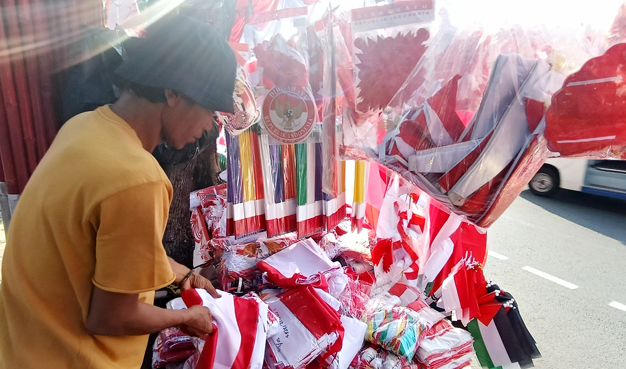 Jelang 17 Agustus, Penjual Bendera Merah Putih Mulai Menjamur di Jatinegara Pedagang musiman bendera dan hiasan bernuansa merah putih menata barang jualannya di pinggir jalan Jatinegara,Rabu (30/7/2025). (Beritanasional.com/Oke Atmaja)