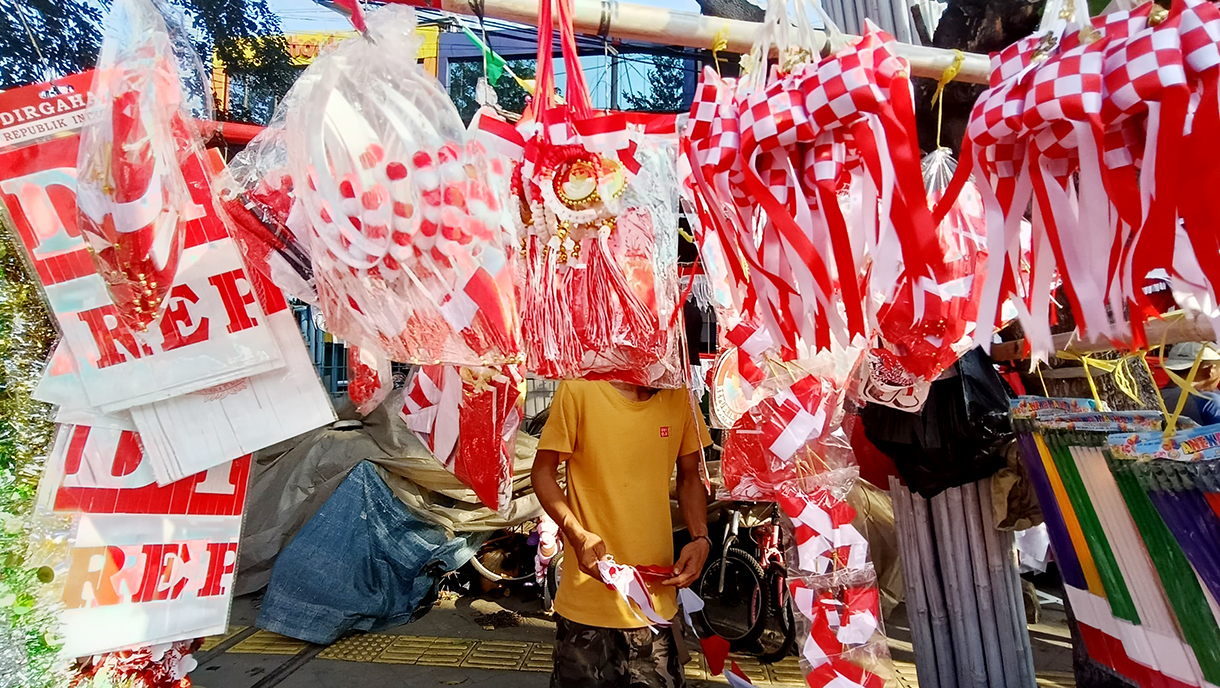 Jelang 17 Agustus, Penjual Bendera Merah Putih Mulai Menjamur di Jatinegara Pedagang musiman bendera dan hiasan bernuansa merah putih menata barang jualannya di pinggir jalan Jatinegara,Rabu (30/7/2025). (Beritanasional.com/Oke Atmaja)
