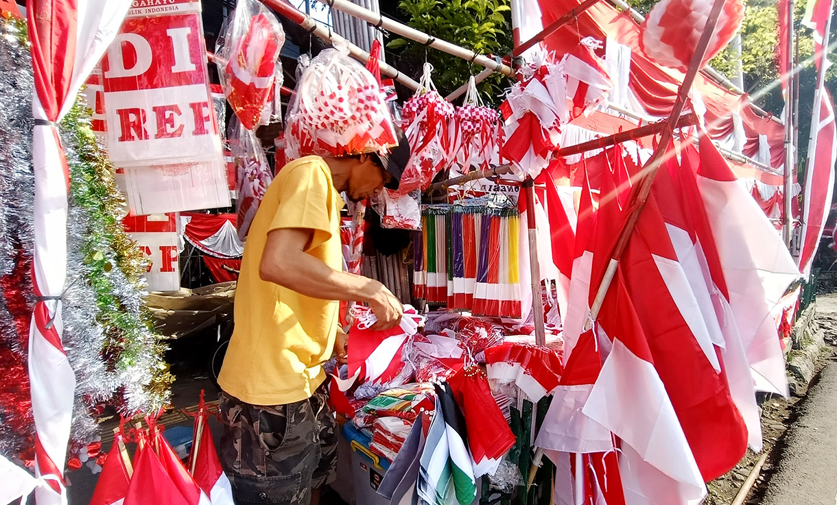 Jelang 17 Agustus, Penjual Bendera Merah Putih Mulai Menjamur di Jatinegara Pedagang musiman bendera dan hiasan bernuansa merah putih menata barang jualannya di pinggir jalan Jatinegara,Rabu (30/7/2025). (Beritanasional.com/Oke Atmaja)
