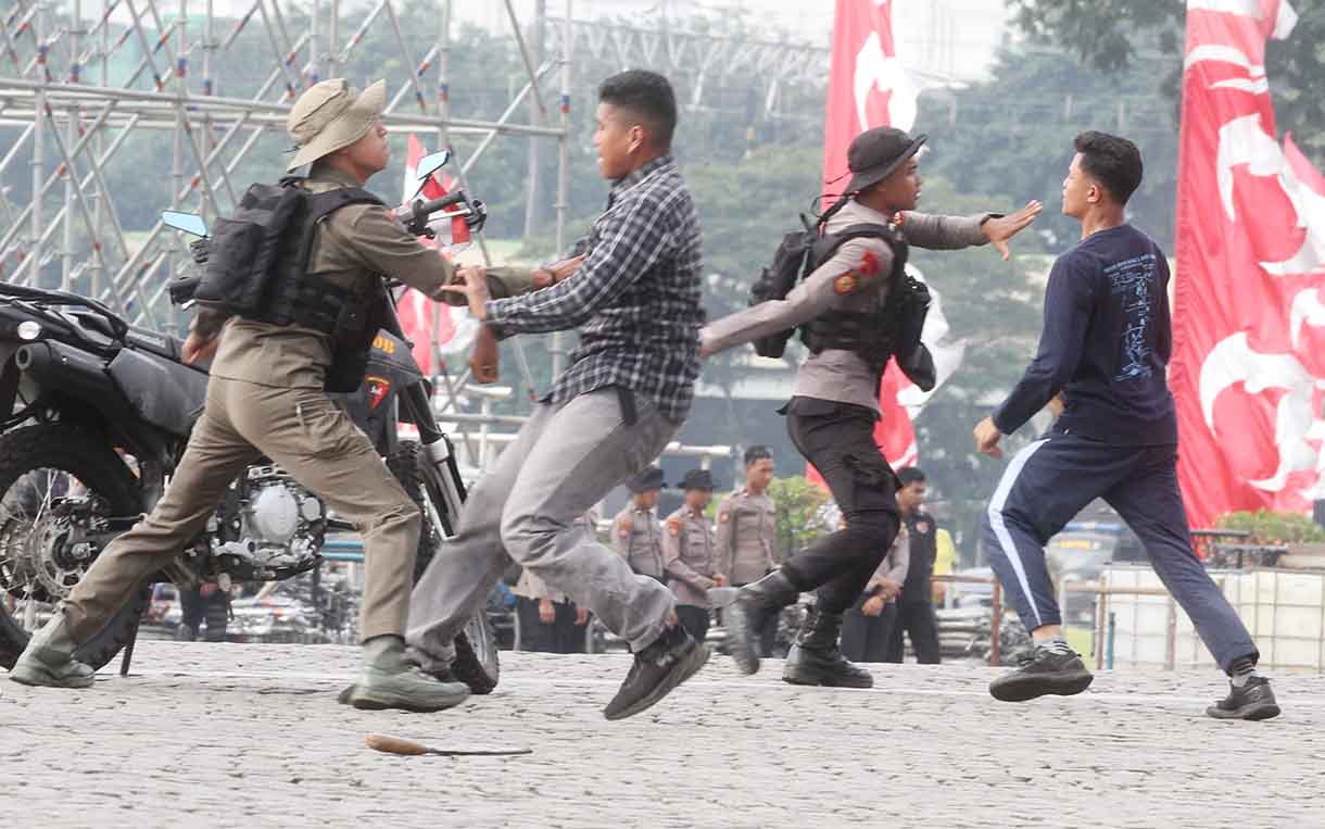 Brimob membubarkan perusuh saat melakukan gladi acara HUT Bayangkara yang ke-79 di Monumen Nasional, Jakarta, Minggu (21/6/2025). (Beritanasional.com/Oke Atmaja)