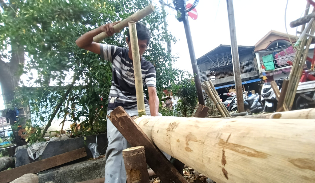 Jelang HUT RI, Penjual Pohon Pinang Mulai Bermunculan Pekerja mengupas kulit batang pohon pinang di kawasan Manggarai, Jakarta, Kamis (7/8/2025). (Beritanasional.com/Oke Atmaja)