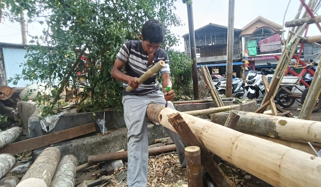 Jelang HUT RI, Penjual Pohon Pinang Mulai Bermunculan Pekerja mengupas kulit batang pohon pinang di kawasan Manggarai, Jakarta, Kamis (7/8/2025). (Beritanasional.com/Oke Atmaja)