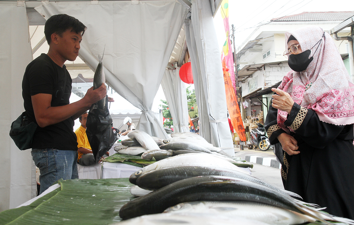 Pedagang sedang menunjukan ikan bandeng di Pasar Rawa Belong, Jakarta Barat, Senin (27/1/2025).(BeritaNasional/Oke Atmaja)