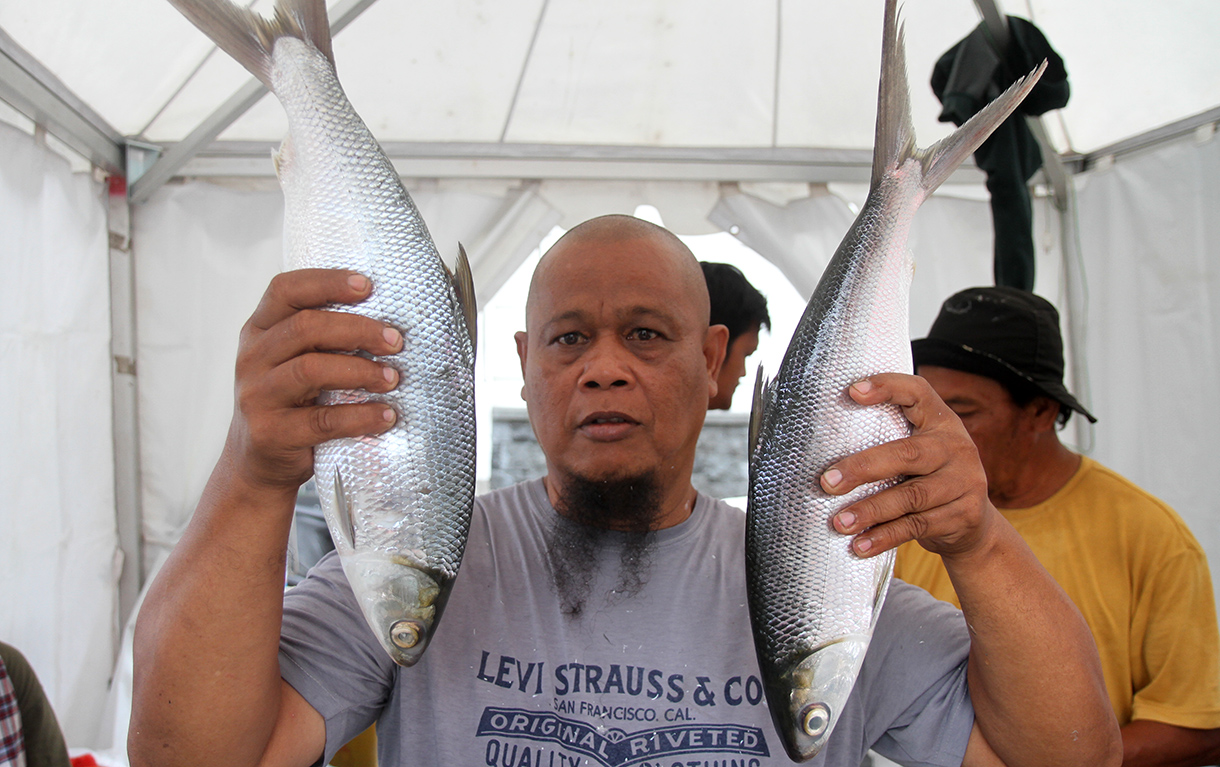 Pedagang sedang menunjukan ikan bandeng di Pasar Rawa Belong, Jakarta Barat, Senin (27/1/2025).(BeritaNasional/Oke Atmaja)