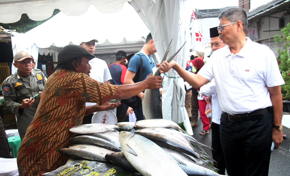 Pedagang sedang menunjukan ikan bandeng di Pasar Rawa Belong, Jakarta Barat, Senin (27/1/2025).(BeritaNasional/Oke Atmaja)