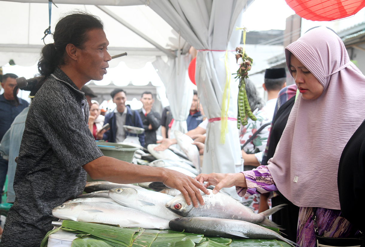 Pedagang sedang menunjukan ikan bandeng di Pasar Rawa Belong, Jakarta Barat, Senin (27/1/2025).(BeritaNasional/Oke Atmaja)