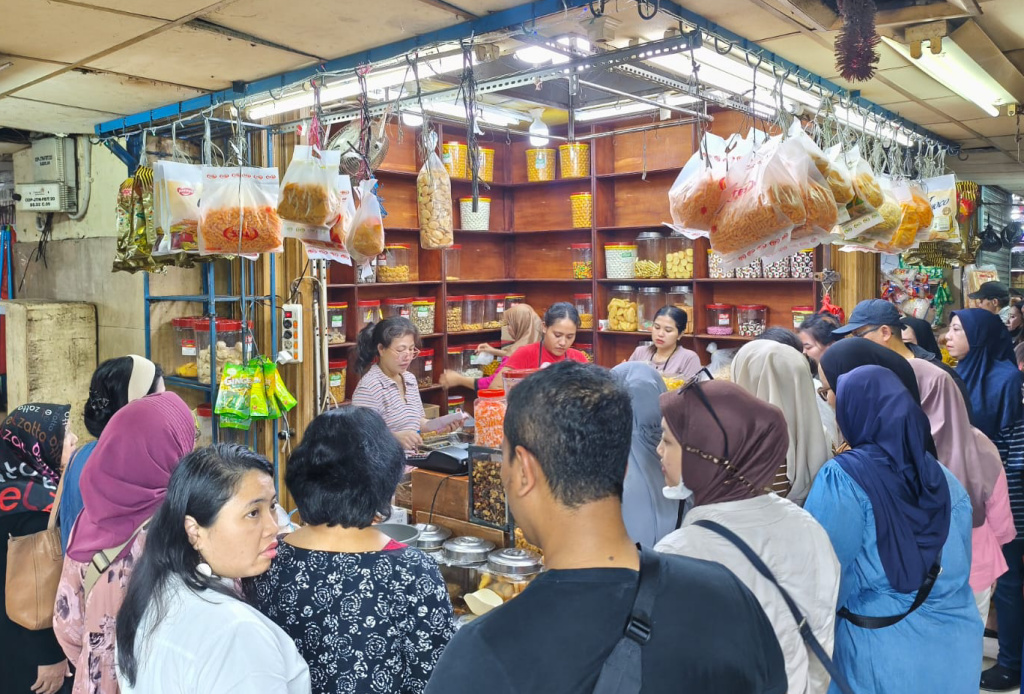 Pedagang melayani pembeli kue kering yang dijual di Pasar Jatinegara, Jakarta Timur, Selasa (17/3/2026). (Beritanasional.com/Oke Atmaja)