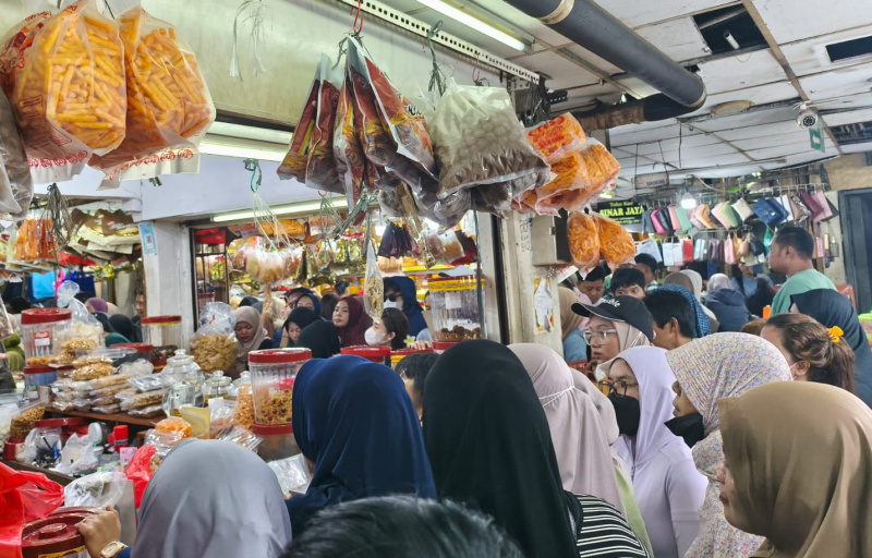 Pedagang melayani pembeli kue kering yang dijual di Pasar Jatinegara, Jakarta Timur, Selasa (17/3/2026). (Beritanasional.com/Oke Atmaja)