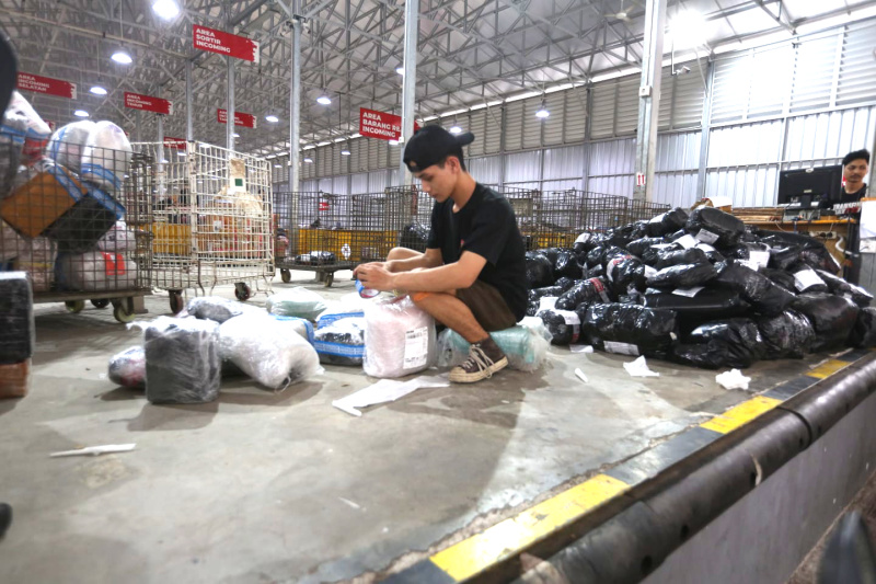 Pekerja memindahkan paket untuk dikirim ke pelanggan di Lion Hub Halim, Jakarta, Kamis (12/3/2026). (Beritanasional.com/Oke Atmaja)