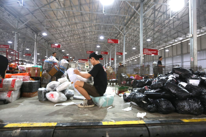 Pekerja memindahkan paket untuk dikirim ke pelanggan di Lion Hub Halim, Jakarta, Kamis (12/3/2026). (Beritanasional.com/Oke Atmaja)