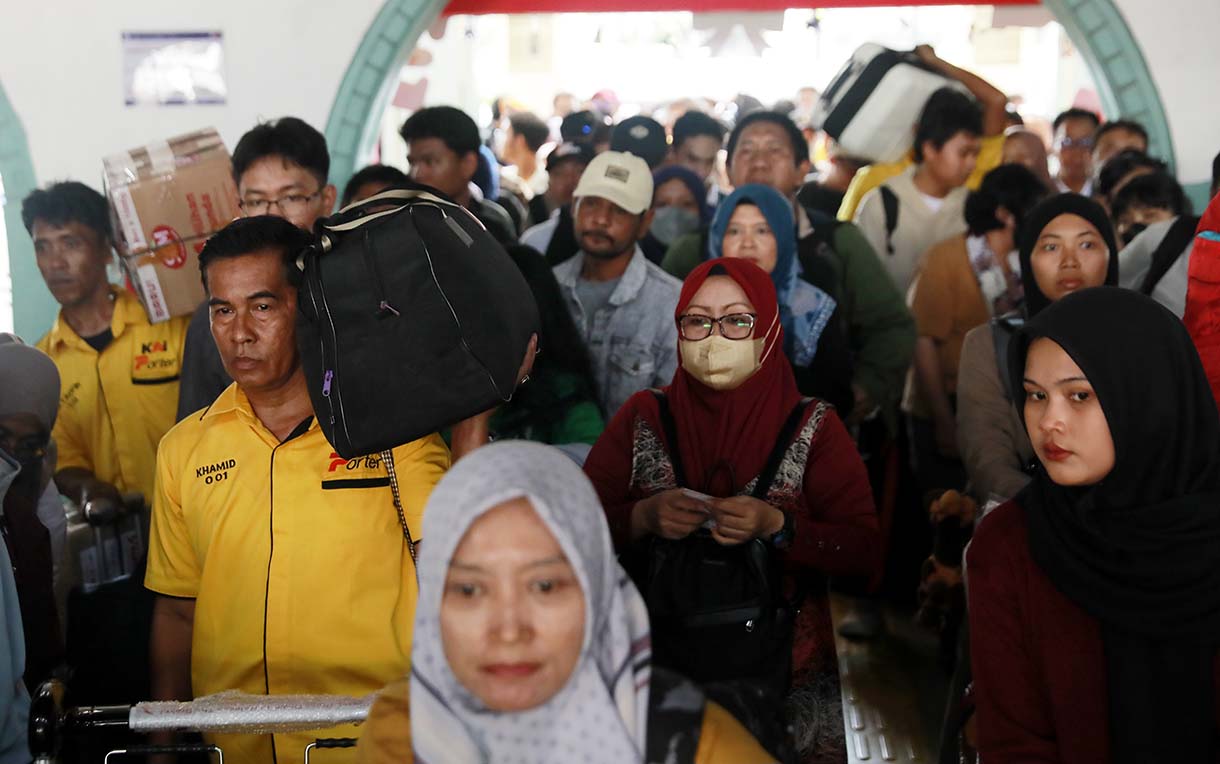 Sejumlah calon penumpang kereta mengantre untuk memasuki peron di Stasiun Pasar Senen, Jakarta, Selasa (23/12/2025).  (Beritanasional.com/Oke Atmaja)